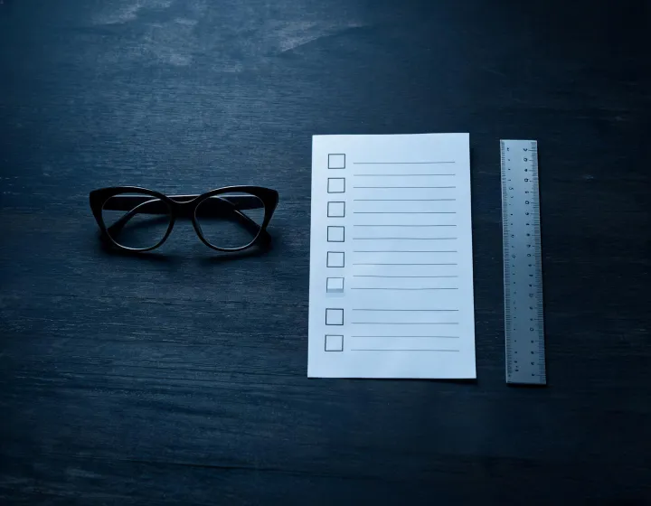 Black cat eye glasses specification checklist on a desk
